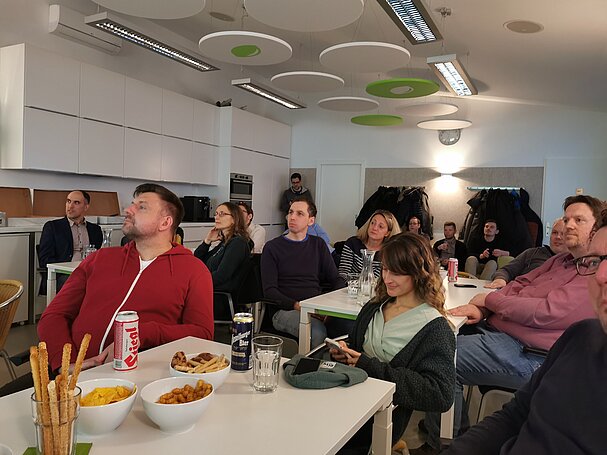 Foto der Zuhörer:innen des 35. Magento Meetup Austria bei uns in der Wiener LIMESODA Lounge. Sie sitzen an Tischen und hören einem Vortrag gespannt zu.