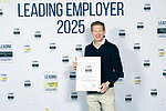 CEO Philipp Pfaller mit der Auszeichnung Leading Employer 2025 vor der Interview-Wand