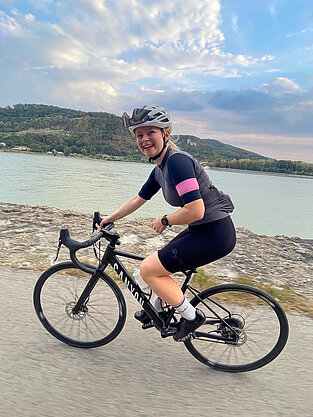 Anna auf dem Rennrad vor der Donau.