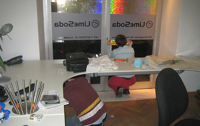 Claudia beklebt die Auslage mit Glitzerfolie