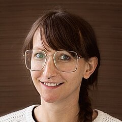 Portrait Marion Mühlberger mit Brille in weißem Strickpullover, Marketing SP-Verpackungen.