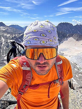 Marcel beim Bergsteigen übder den Gipfeln.