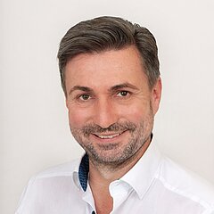 OeSV Präsident Dieter Schneider, Portraitfoto in weißem Hemd.