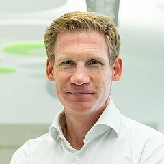 Portrait LIMESODA Geschäftsführer Dr. Philipp Pfaller in weißem Hemd im Besprechungsraum LimeLounge. Foto Daniel Shaked.